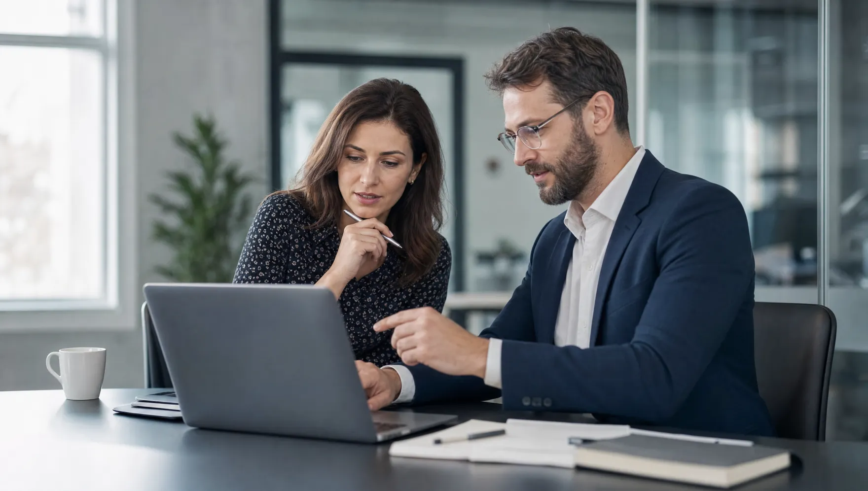 Zwei Kolleginnen und Kollegen arbeiten gemeinsam an der IT
